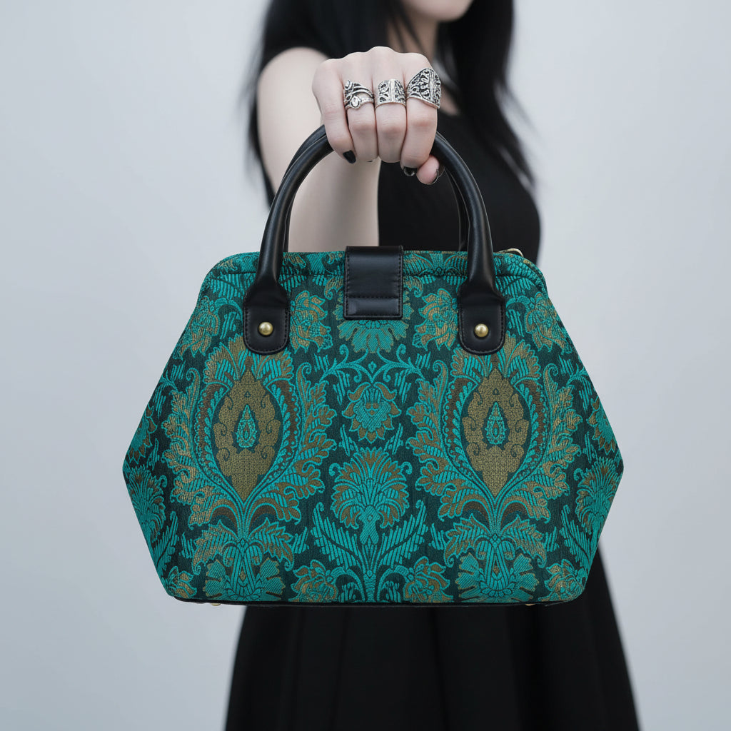 Teal patterned handbag with black handle on a white background