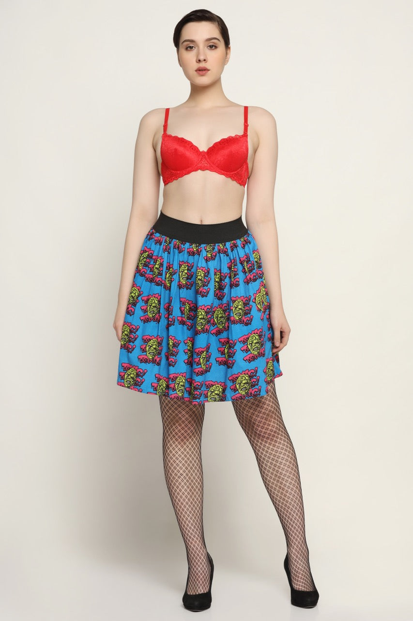 A model wearing a red bra and a blue and red skirt with a geometric pattern.