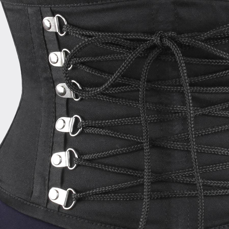 Black corset with laces and metal hooks on a white background