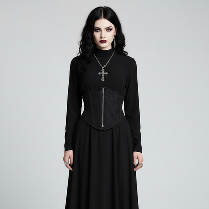 A model wearing a long-sleeved black gothic maxi dress with a structured corset-style bodice and a silver front zipper, styled with a silver cross necklace against a light gray studio background.