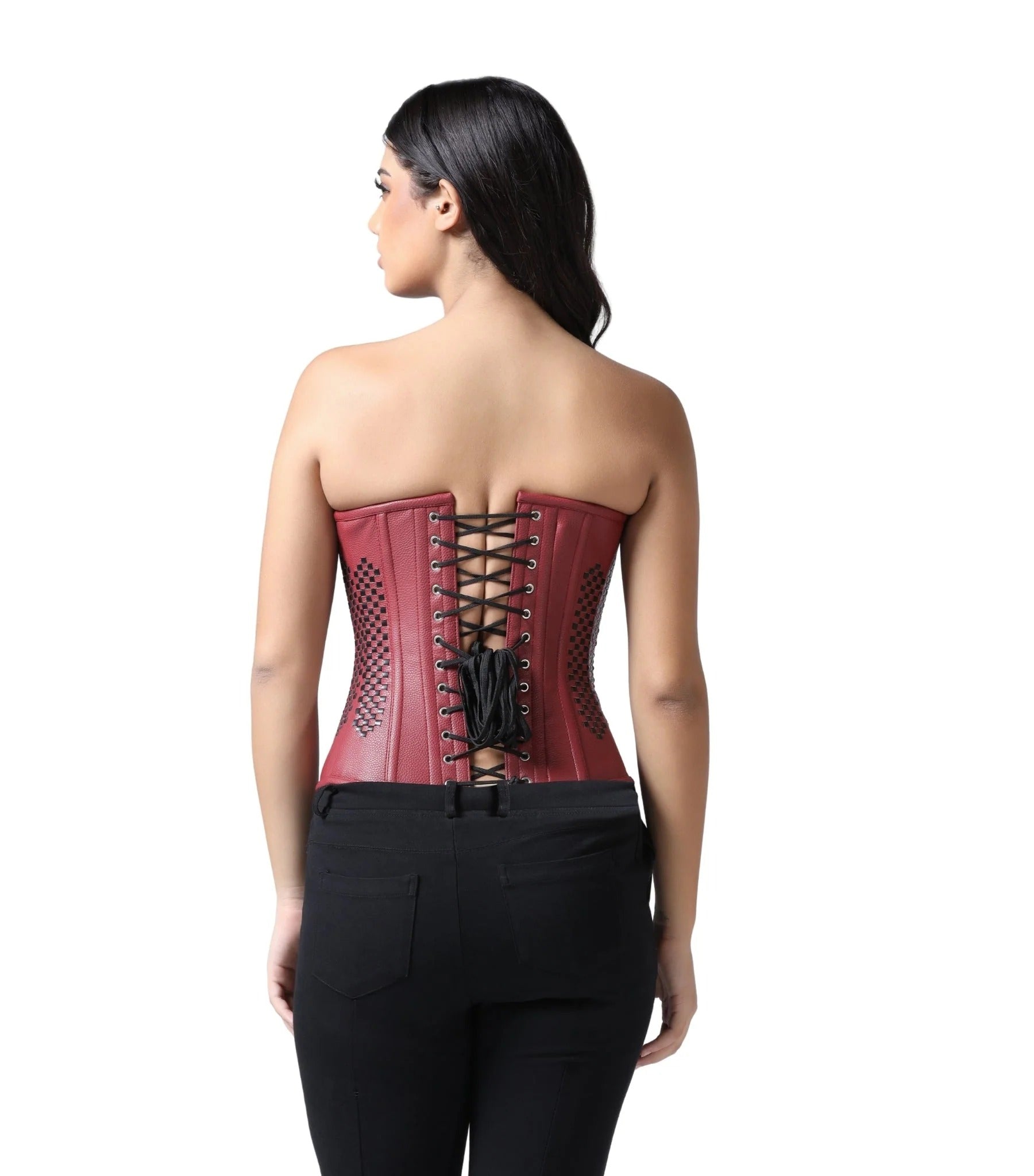 A woman shown from the back wearing a red strapless corset with black laces and black pants, photographed against a plain white studio background.